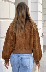 Rear view of a tan suedette bomber jacket with a ribbed hem and cuffs, showing the relaxed fit and voluminous sleeves
