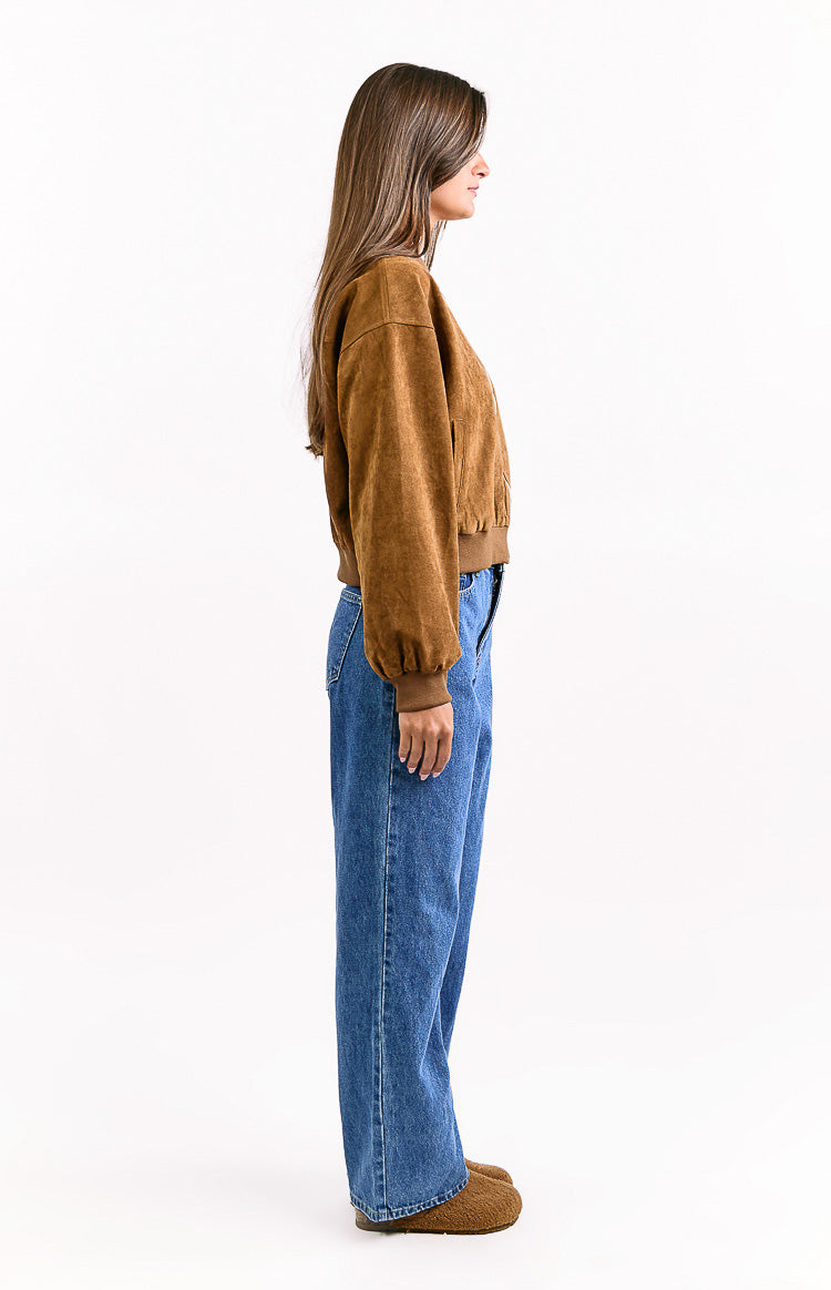 Side view of a tan suedette bomber jacket with cuffed long sleeves and a ribbed hem