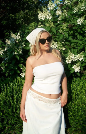 Close-up of the white midi skirt showing the delicate lace trim detail at the waist