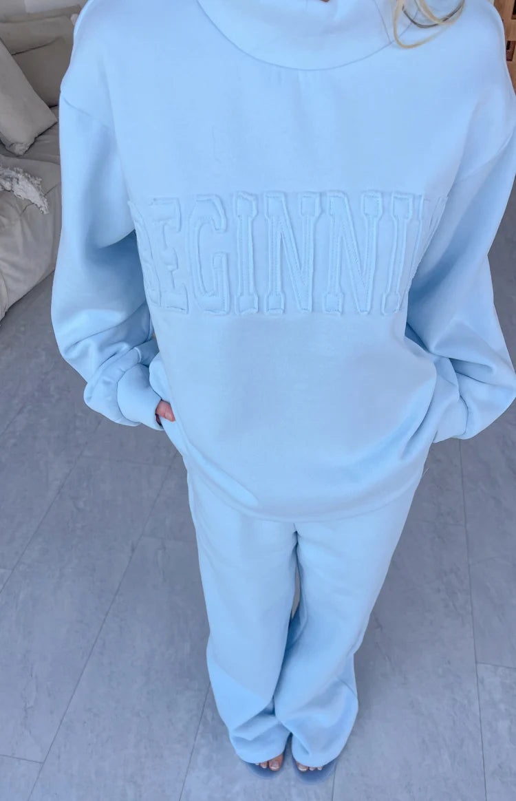 Textured applique lettering on a light blue mock neck sweater with a relaxed fit