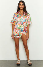 Front view of a colourful abstract print satin shirt with short sleeves and an open collar