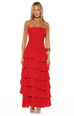 Front view of a red strapless maxi dress with a shirred bodice and a tiered, asymmetrical ruffle skirt