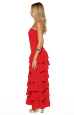 Side view of a red strapless maxi dress with a shirred bodice and a tiered ruffle skirt