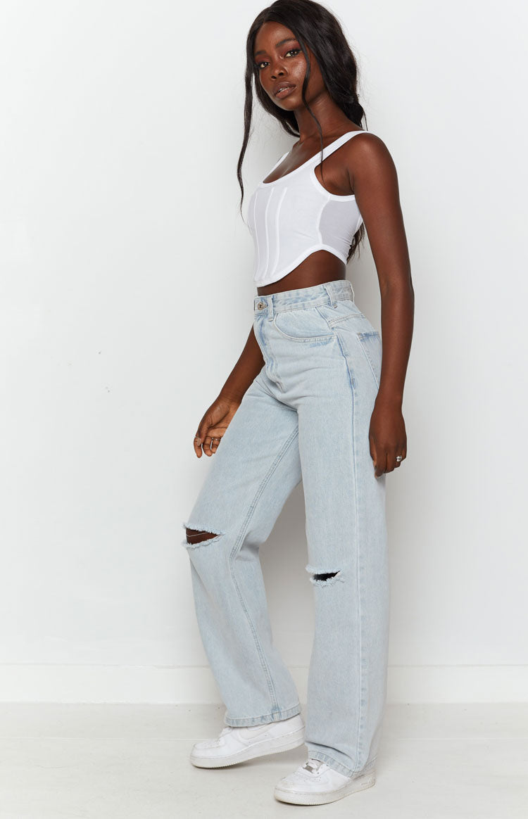 Light wash blue wide leg denim jeans with a high waist and ripped knees