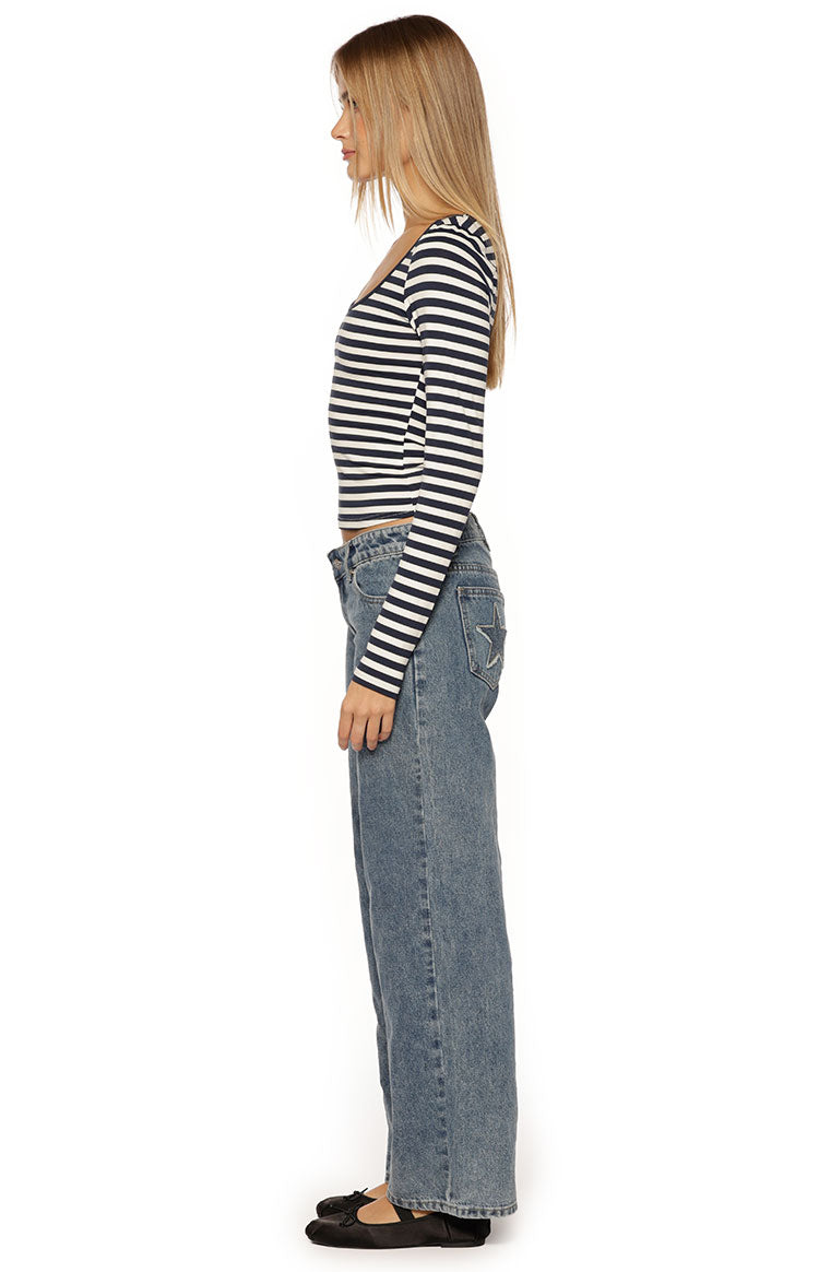 Side view of a navy and white striped long sleeve top with a scoop neck and fitted, cropped silhouette