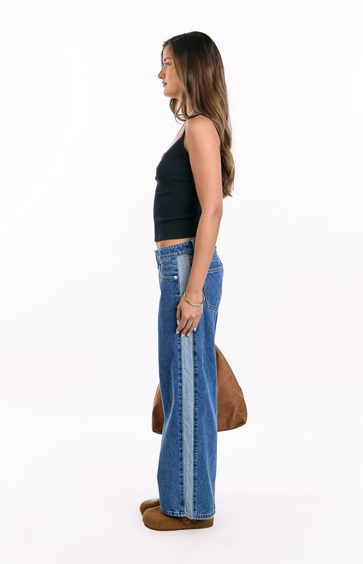 Side view of mid wash denim low rise jeans with a lighter blue contrast stripe down the side
