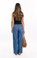 Back view of mid wash denim low rise jeans featuring a relaxed straight leg and classic back pockets