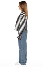 Side view of mid wash ripped jeans with a wide-leg fit and knee rip detail