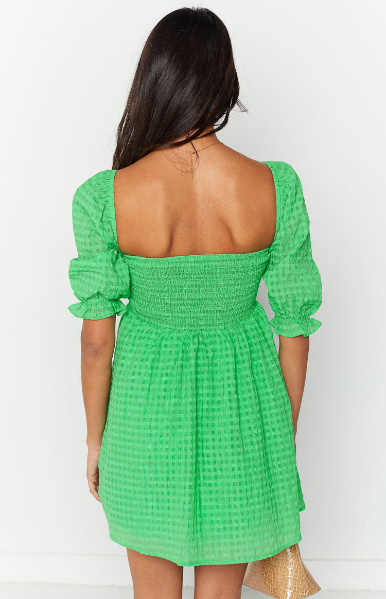 Rear view of a green checkered babydoll mini dress with a square back neckline, shirred bodice, and puffed sleeves