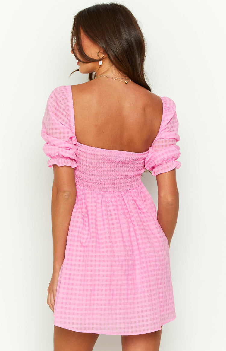 Close-up of the pink babydoll mini dress showing the subtle check texture, puffed sleeves, and ruffled cuffs
