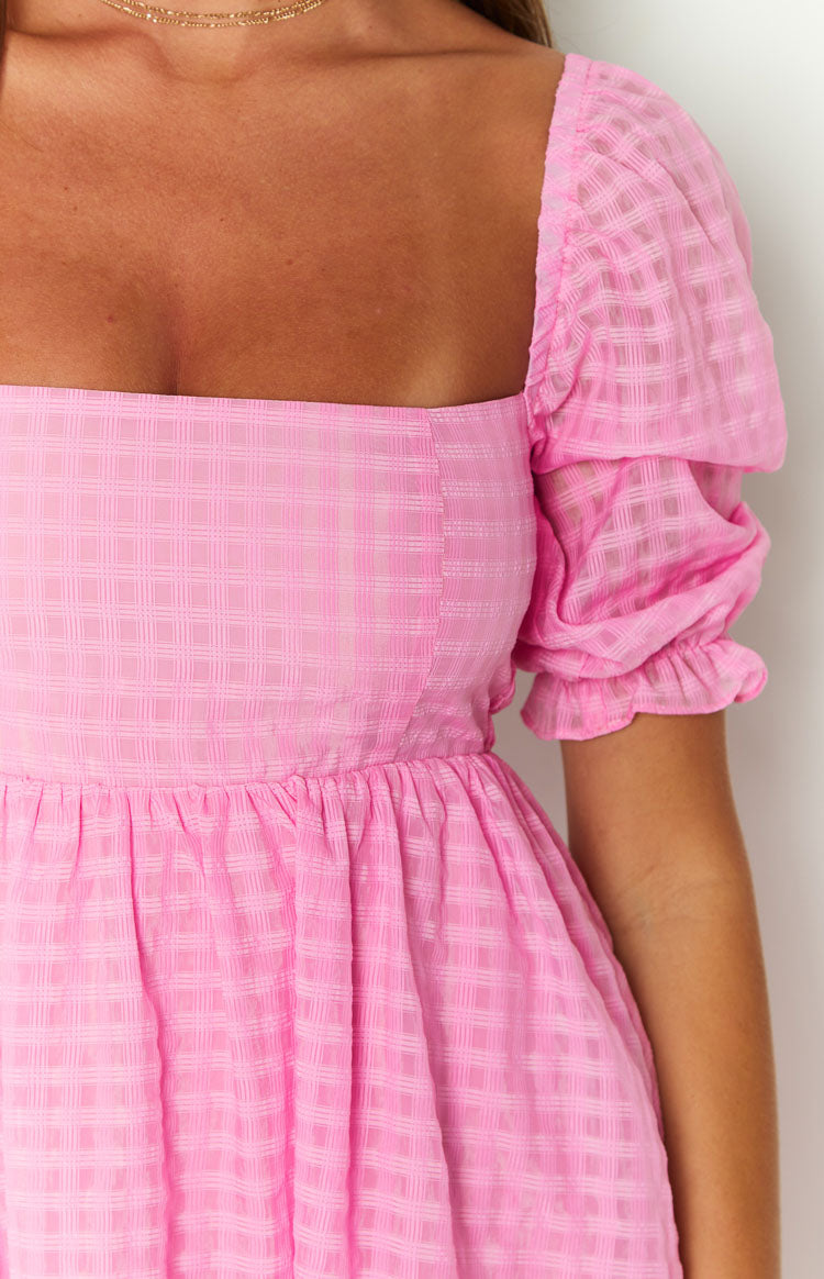 Rear view of a pink gingham babydoll mini dress with a low square back and shirred bodice