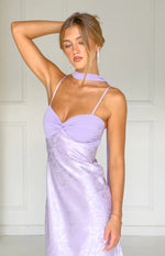 Close-up of the lilac maxi dress with a twisted solid bust, floral satin skirt, thin spaghetti straps, and scarf neckline