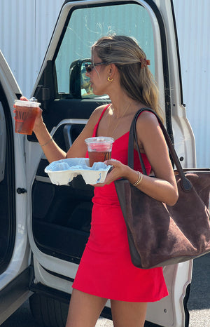 Side view of a fitted red mini dress with thin spaghetti straps and a smooth fabric
