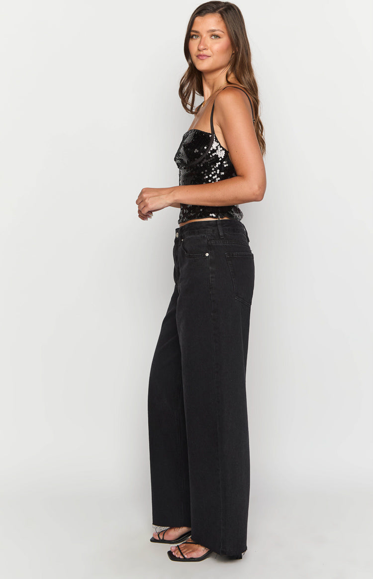 Side view of black wide-leg boyfriend jeans with a relaxed fit and frayed hem