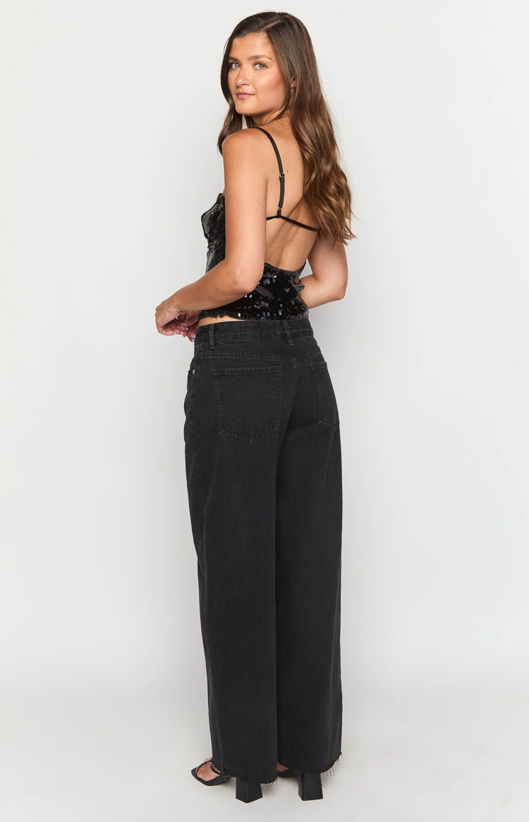 Rear view of black wide-leg boyfriend jeans with back pockets and a raw hem