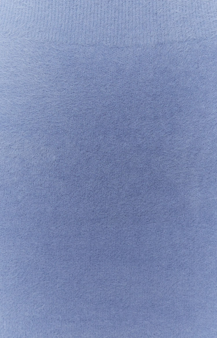 Periwinkle blue fluffy knit fabric close-up with a soft texture and ribbed top edge