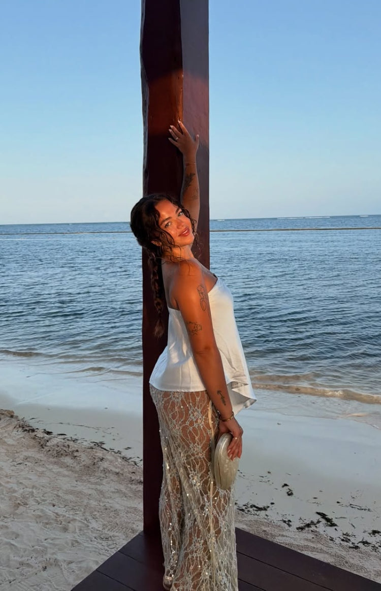 Side view of a pale yellow sequin lace maxi skirt with a sheer floral pattern