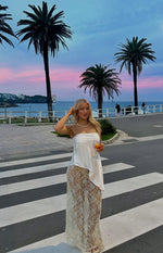 Full length view of the sheer white lace maxi skirt with an intricate pattern and sparkling blue sequins