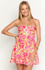 Close-up of the yellow floral mini dress with a sweetheart neckline and white bobble trim