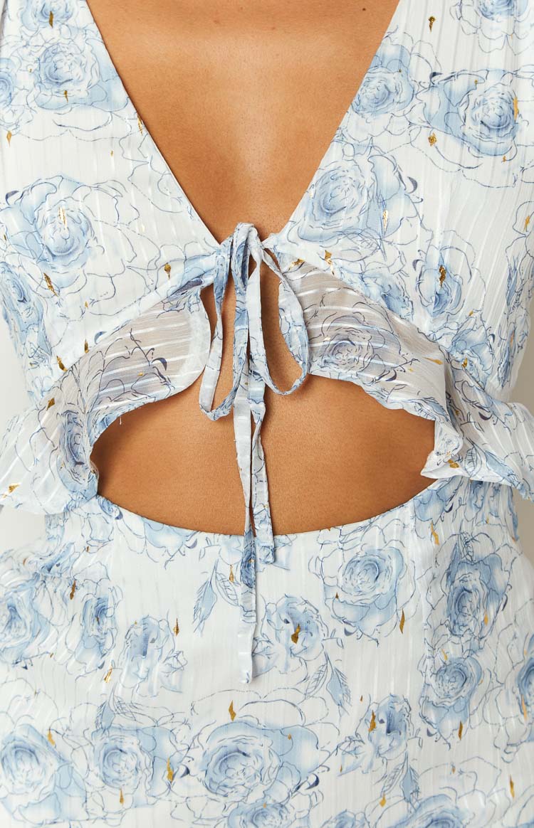 Close-up of the tie-front V-neckline and underbust cutout on the textured white blue floral mini dress with gold accents