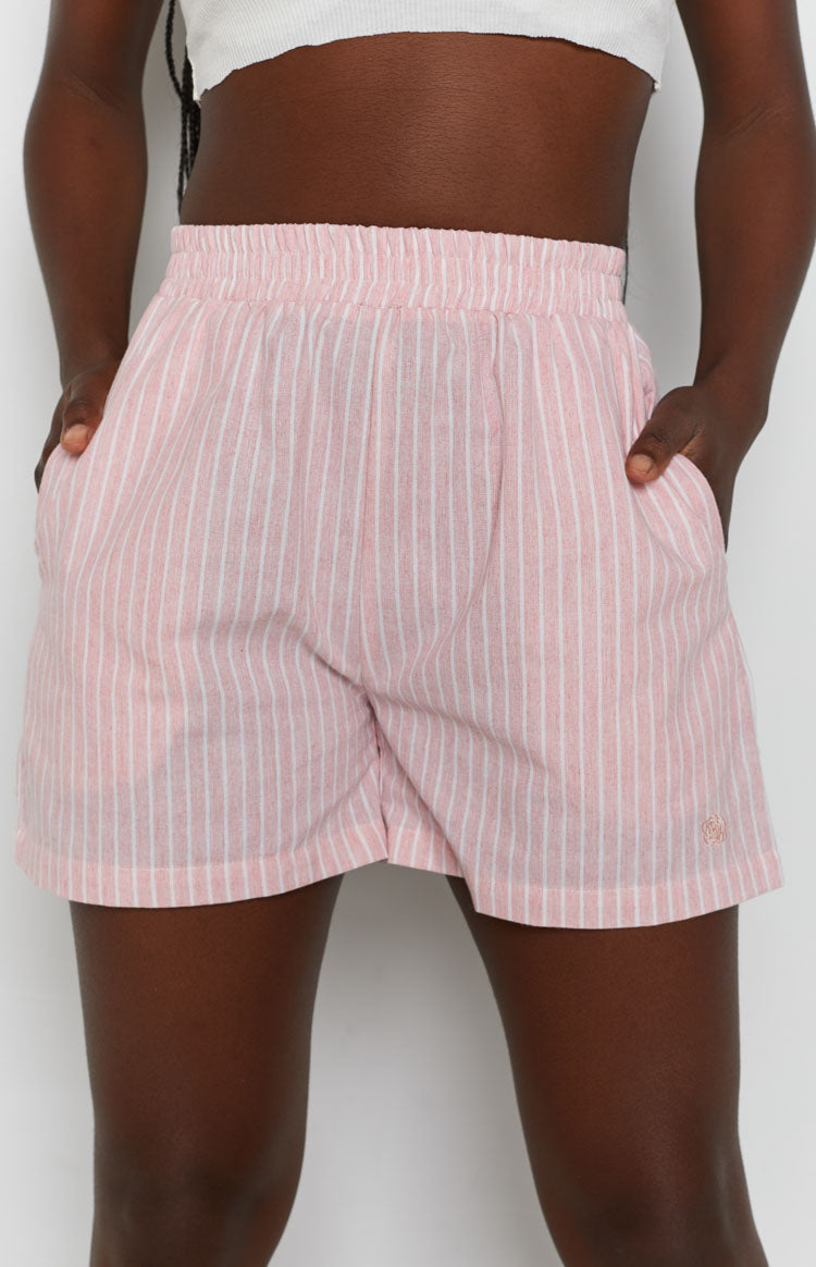 Pink pinstripe shorts with elasticated waistband, side pockets, relaxed fit, and embroidered logo