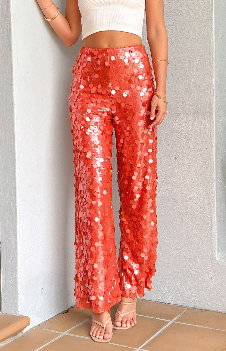 Side view of orange sequin wide-leg pants with a high waist and full sequin coverage