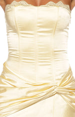 Close-up of the yellow satin strapless bodice with lace trim, corset seaming, and ruched twist waist detail