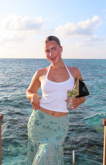 Front view of a white ribbed halter neck top with a fitted, cropped silhouette