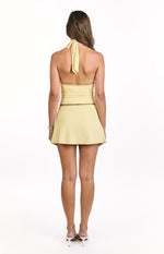 Back view of a yellow halter top with a tie closure at the neck and a fitted, bandeau-style back