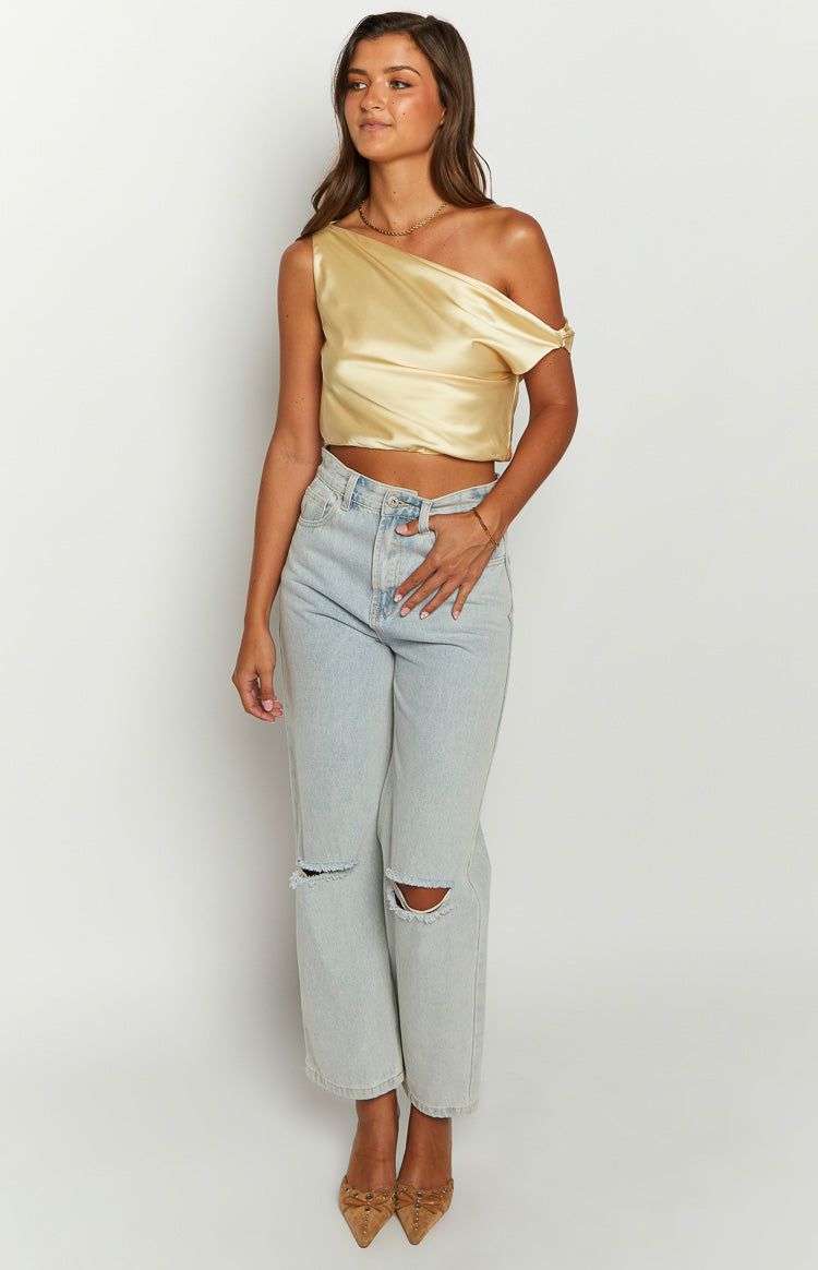 Yellow satin one-shoulder crop top with a draped off-shoulder sleeve and a fitted cropped hem