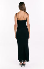 Rear view of a black maxi dress with thin spaghetti straps, a straight back, and a sheer ruffled hem