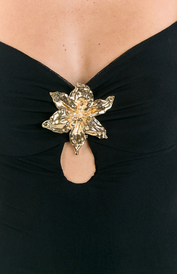 Close-up of the gold hibiscus trim and keyhole cutout on the black ruched neckline