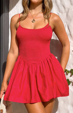 Close-up of a red mini dress with a shirred bodice, thin spaghetti straps, and a gathered flared skirt