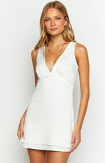 Close-up of the white satin mini dress with a deep V-neckline and gathered detail under the bust
