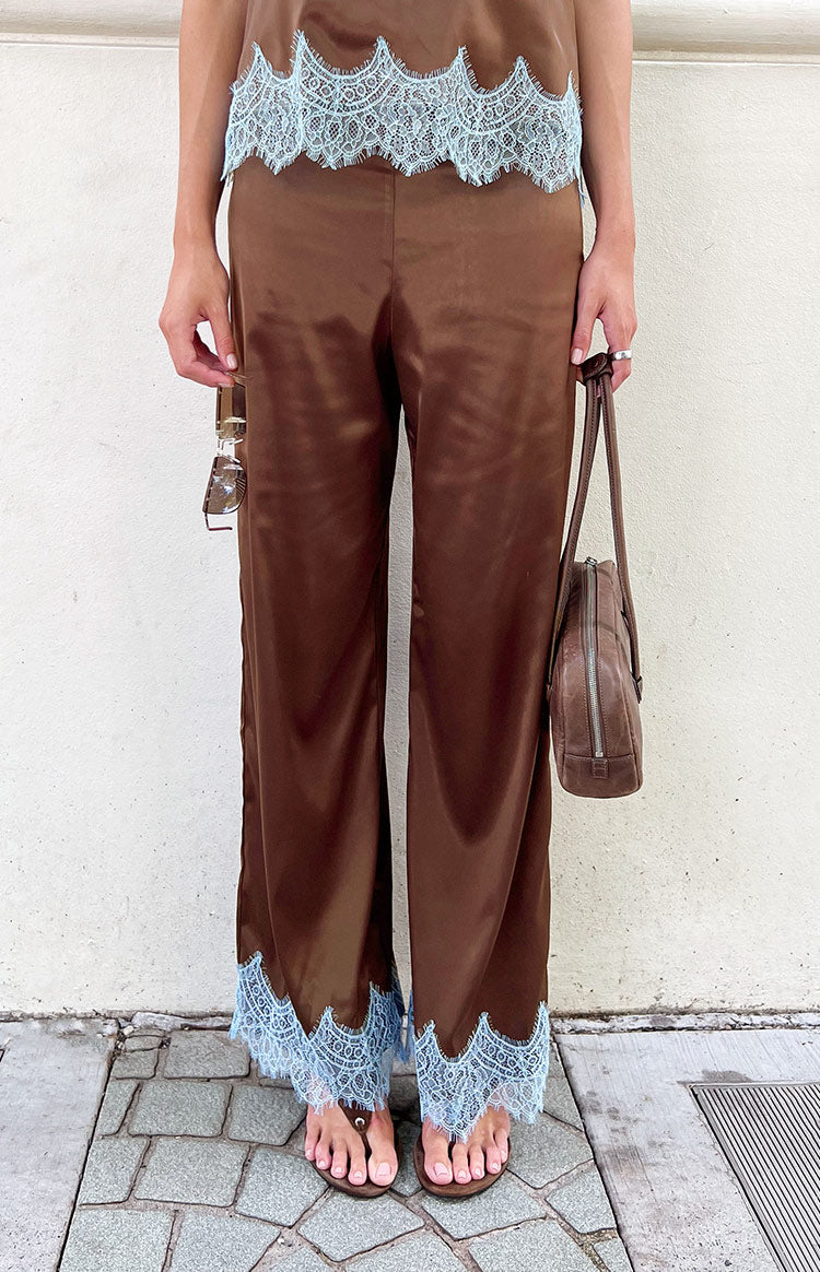 Full length view of brown satin wide-leg pants with light blue scalloped lace trim at the hem