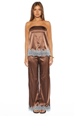 Full length view of brown satin wide-leg pants with light blue scalloped lace trim at the hem