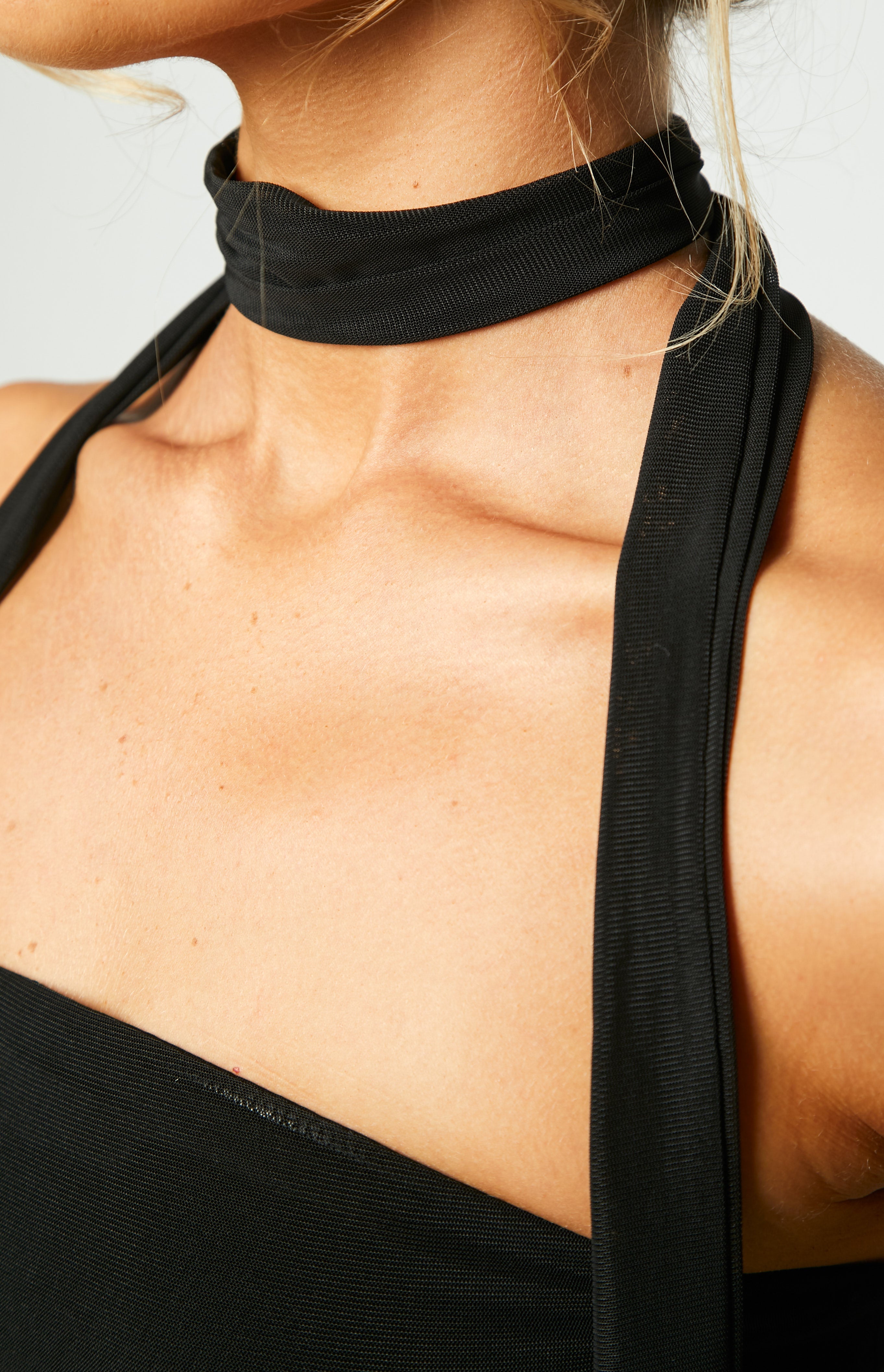 Close-up of the fine black mesh fabric on the strapless mini dress bodice, showing subtle side ruching