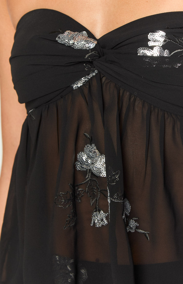 Rear view of a black strapless top with a sheer overlay and silver sequin floral embroidery