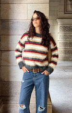 Front view of an oversized multi-stripe fuzzy sweater with dark grey, white, beige, and red stripes, ribbed cuffs and hem