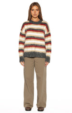 Front view of an oversized multi-stripe sweater with red, cream, beige, and dark grey stripes and a fuzzy knit texture