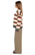 Side view of an oversized fuzzy multi-stripe sweater with a V-neck and long sleeves