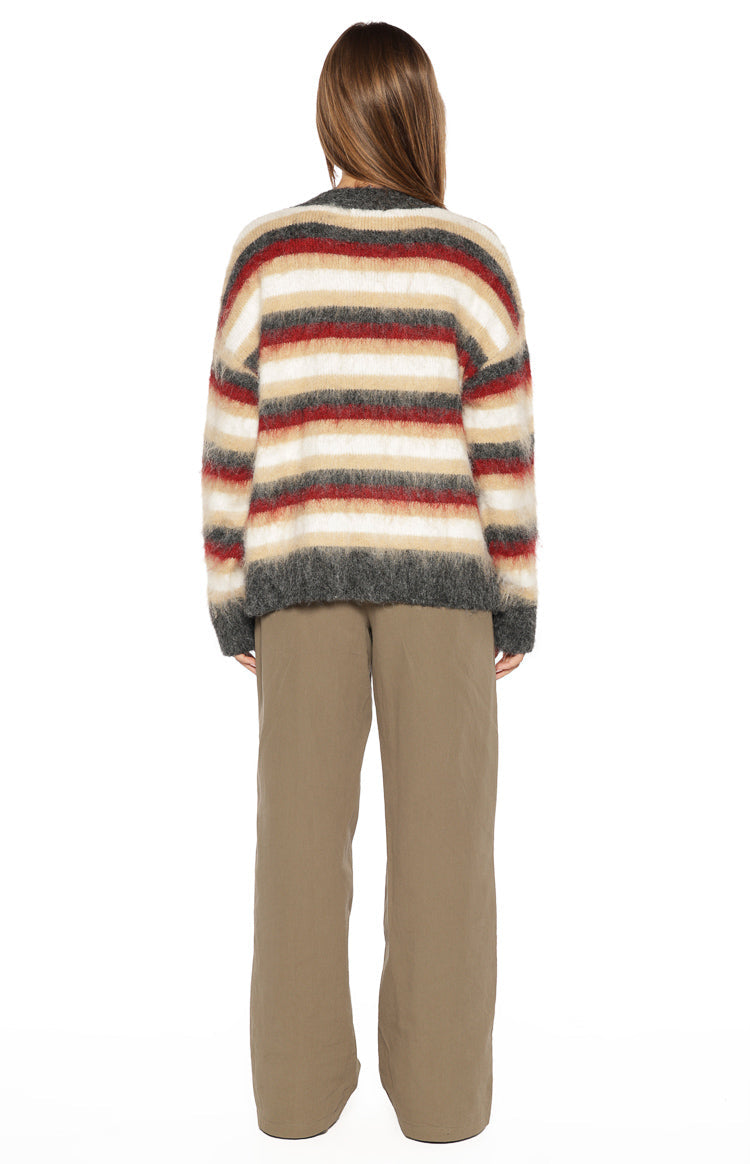 Back view of the red, white, beige, and grey striped oversized sweater with a fluffy knit