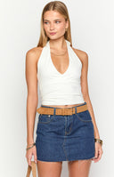 Girl wearing a dark wash denim mini skirt with white contrast stars on the back pockets- styled with a basic white top
