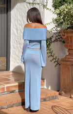 Rear view of a blue shimmer knit maxi skirt with a fitted waist and straight silhouette