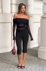 Black mesh off shoulder top with draped neckline, ruched bodice, sheer panels, and lettuce hem long sleeves