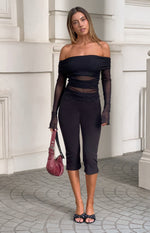 Black off shoulder top with draped neckline, sheer mesh long sleeves and midriff panels