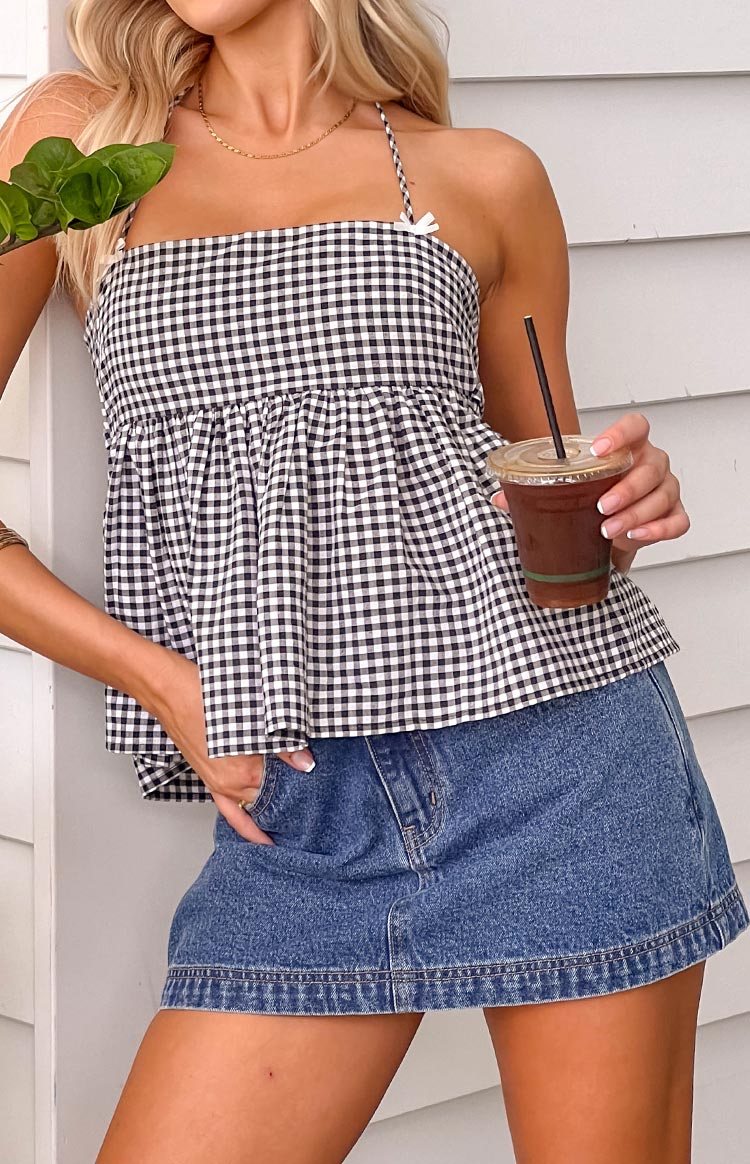 Close-up of the mid-wash denim skort, showing the front pocket, distressed texture, and double-stitched hem