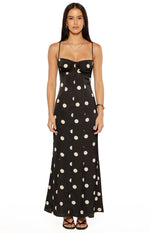Black satin maxi dress with white polka dots, a fitted ruched bust, and delicate spaghetti straps
