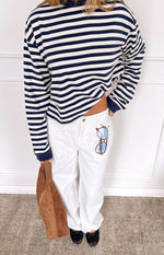 Cropped front view of a navy and white striped long sleeve top with a relaxed fit and high neck