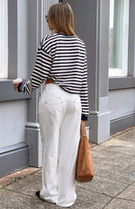 Rear view of a navy and white striped long sleeve top with a relaxed, slightly cropped fit and navy cuffs